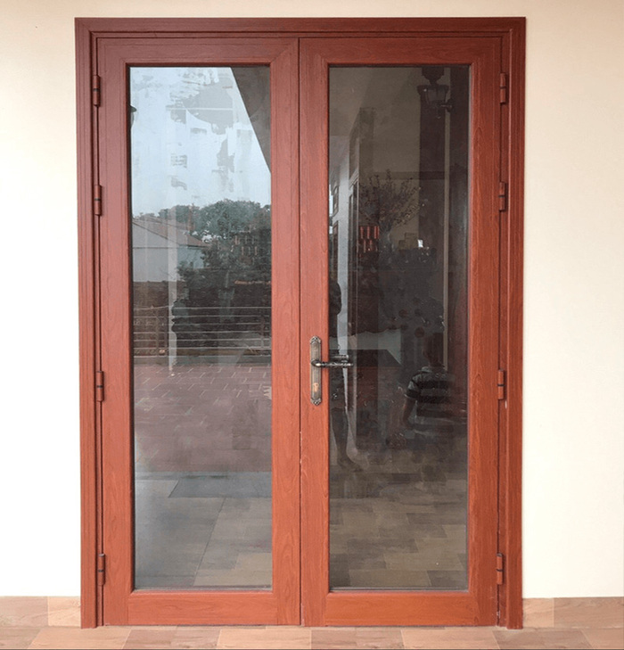 Cửa đi 2 cánh mở quay vân gỗLựa chọn hoàn hảo cho lối ra ban công. Sự kết hợp giữa nhôm vân gỗ và kính cường lực giúp đón ánh sáng tự nhiên nhưng vẫn giữ được nét cổ điển.
